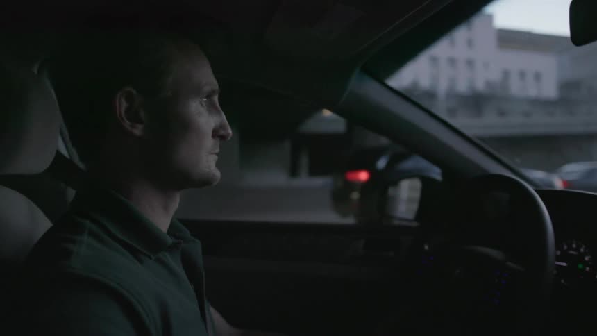 A man drives a car in a city