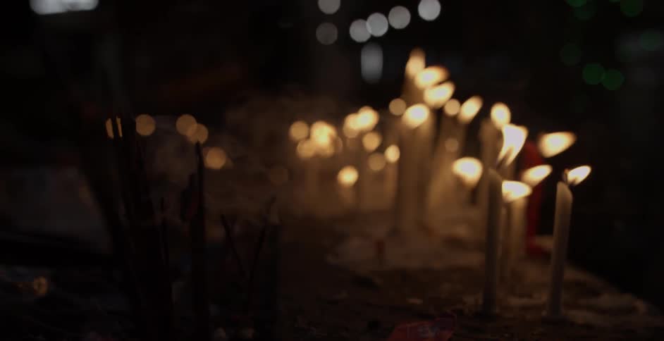Candles burn and blow in the breeze