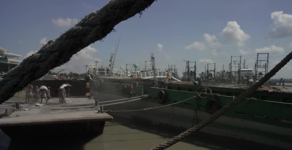 People walk across ropes to a boat