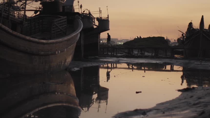 People walk amongst ruins and water