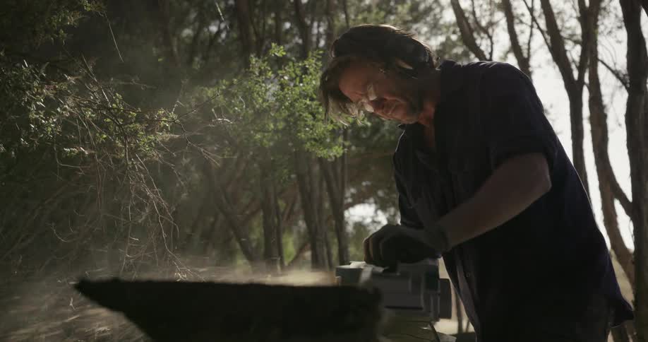 A man sands a piece of wood