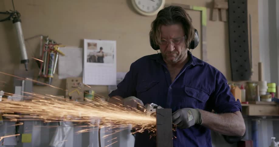A man saws a strip of metal