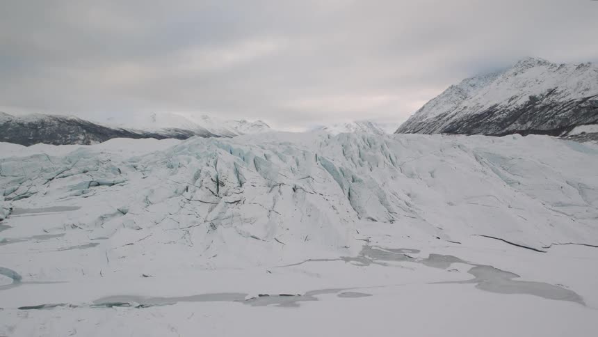 Ascending up the face of a glacial ice field surrounded by mountains