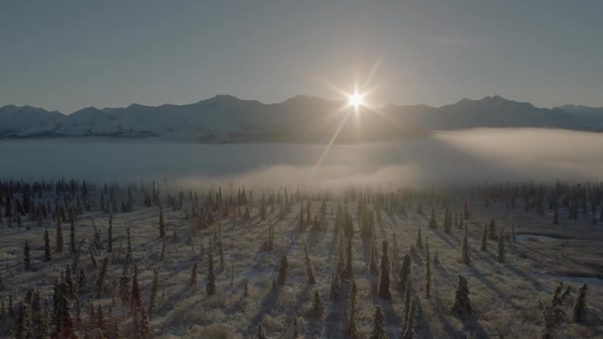 Flying through a mountain valley winter wonderland