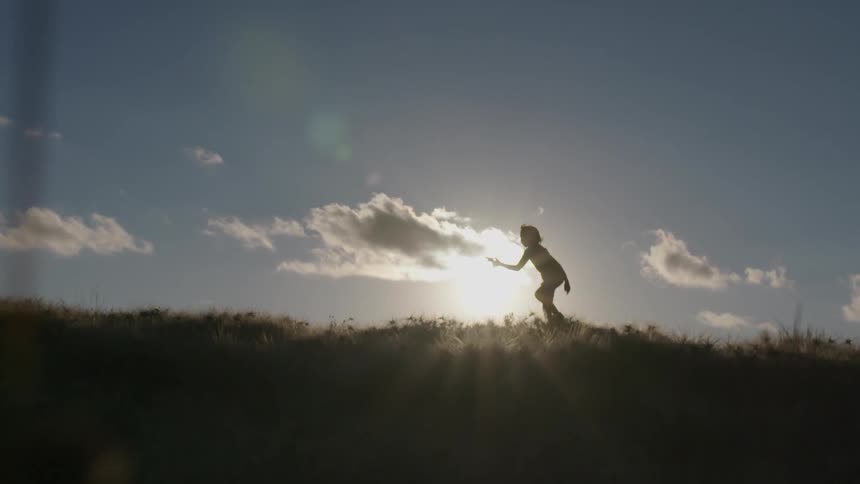 A person is hiking in the grass on the hillside