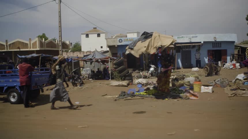 People mill about a market area in an african rural area