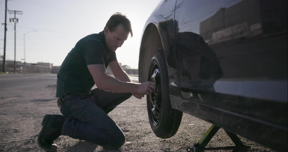 Man fixes the tire on his car