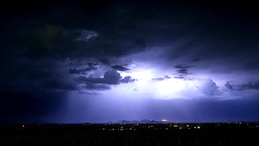 Lightning flashes in the storm clouds above the town