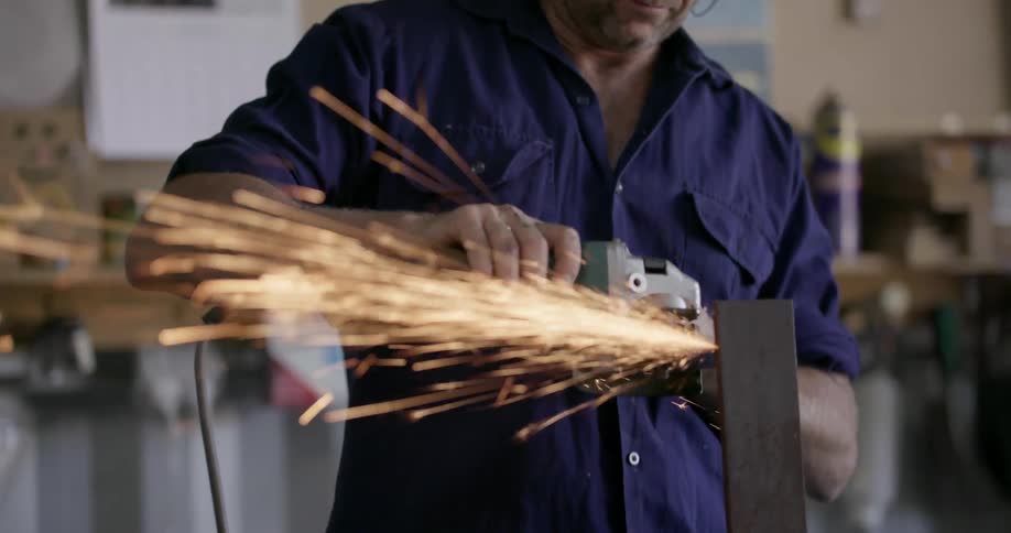 A man saws a strip of metal