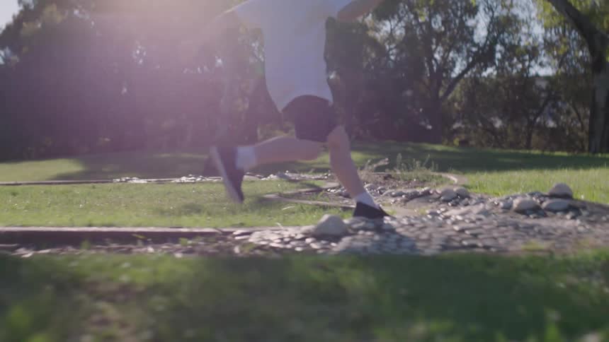 A boy is running along the rocks in the yard