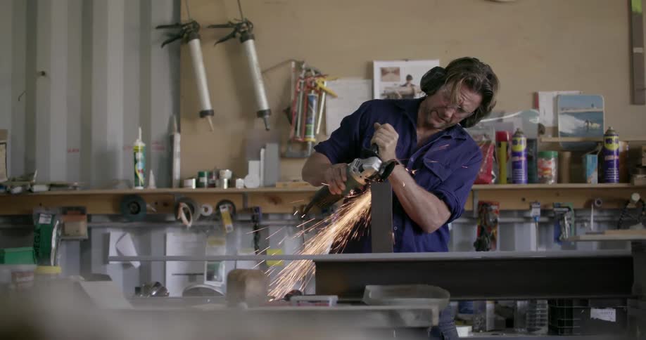 A man is sawing with a large tool