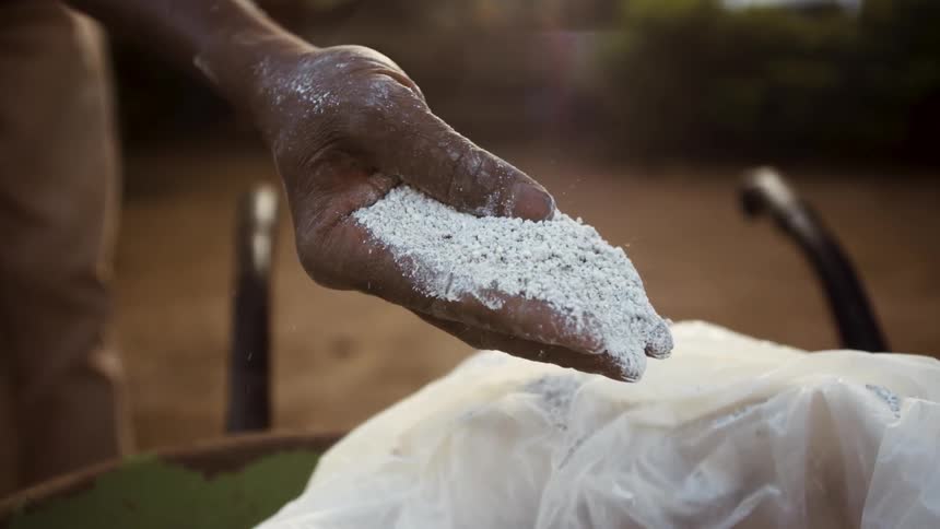 A man holds white substance in his hand