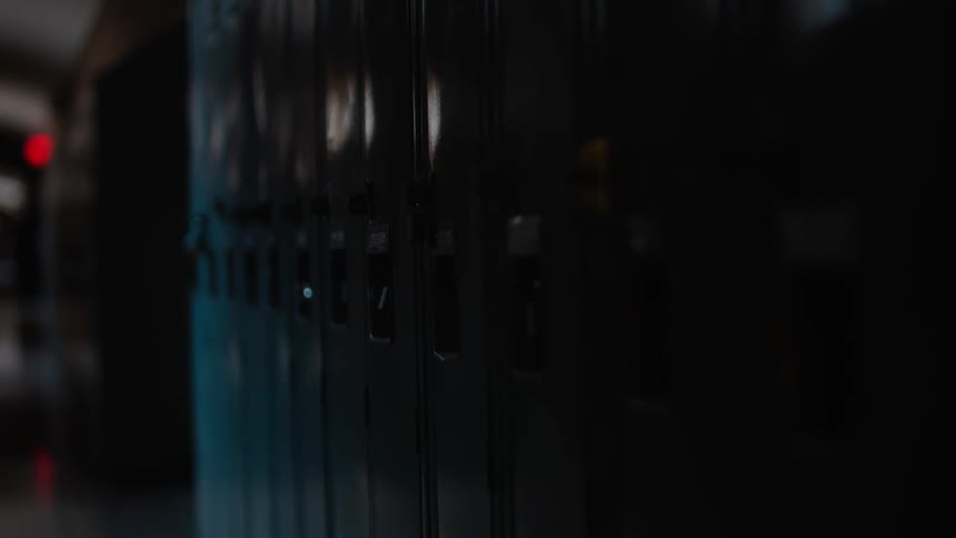 The hallway of the school is dark and empty