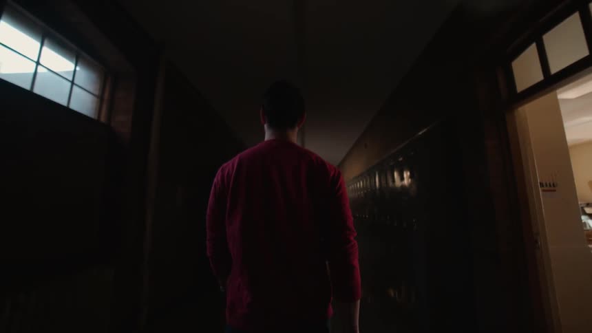 Man walking in a dimly lit area through a building