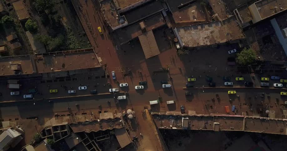 Traffic and pedestrians flow through an urban area in a third world country
