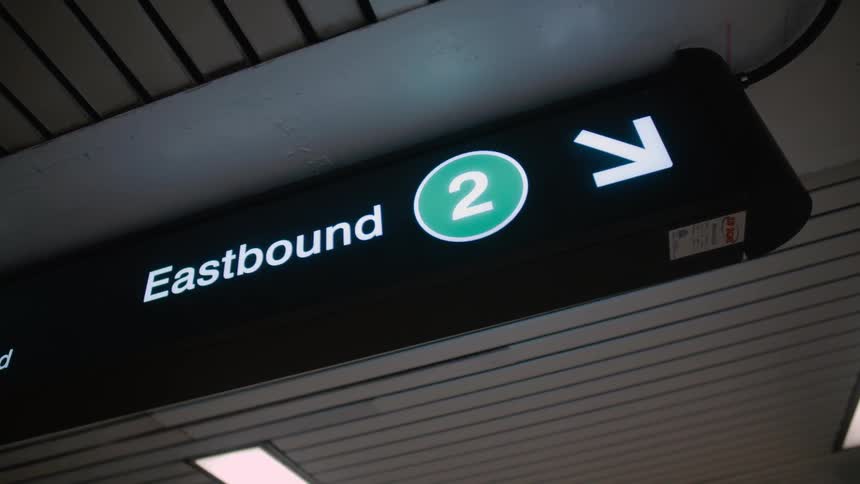 A sign points to a platform in a transit center