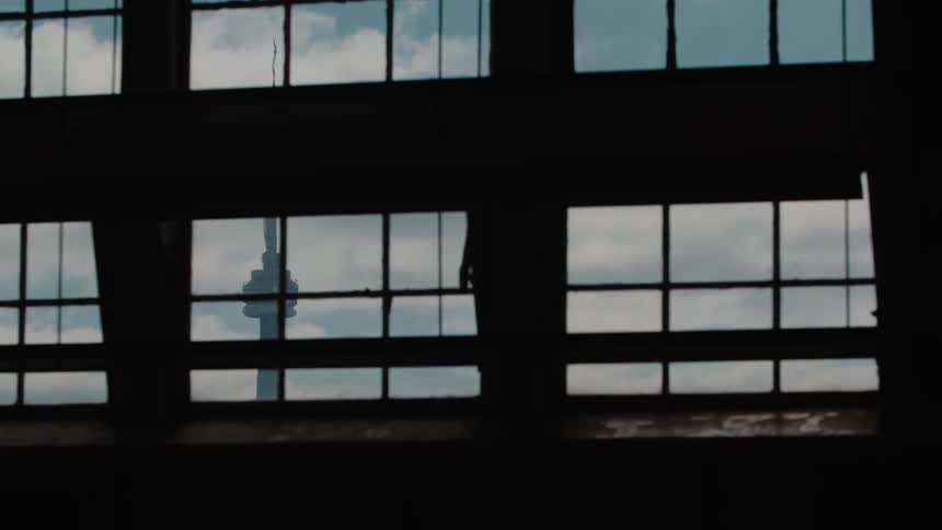 A cloudy sky as seen through some windows from inside a tall building