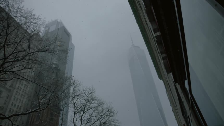 The freedom tower as seen from the ground view on a hazy, snowy day
