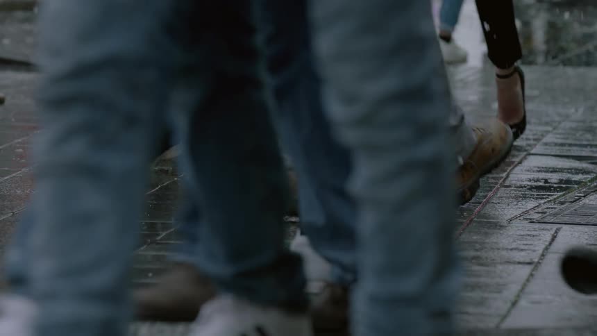 People walking on wet sidewalk while it snows