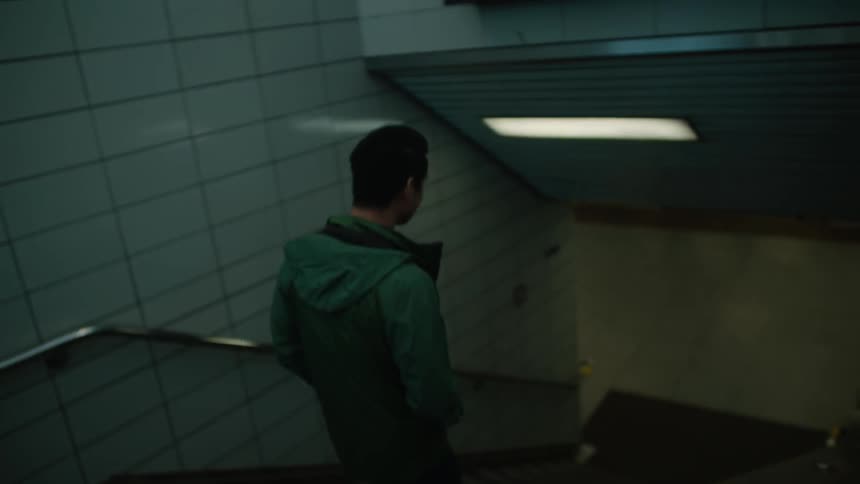 A man walks down the steps to the subway