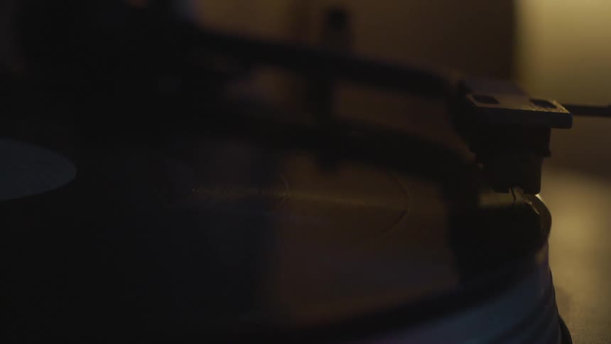 The tone arm and needle cartridge descend on a record player