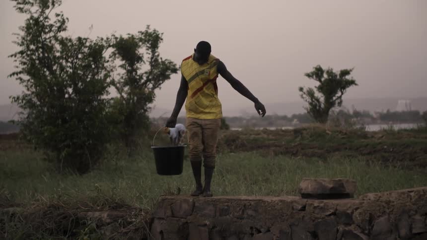 A man carries a bucket of water