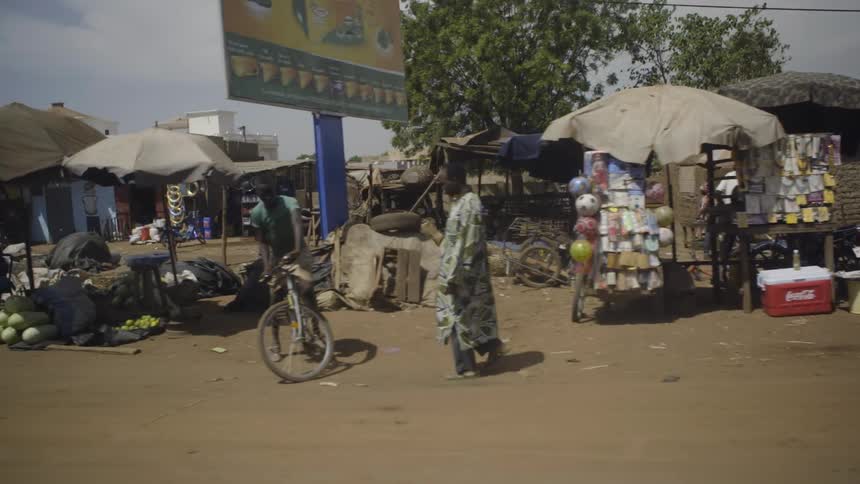A person walks past the carts and stands of an open air market