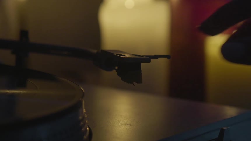 Woman adjusting settings and moving tonearm on record player