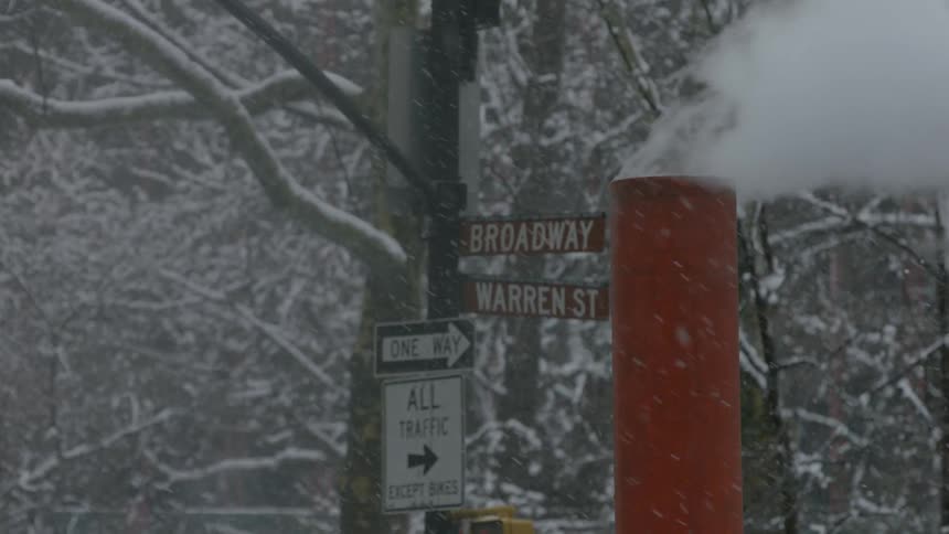 Smoke rises out of a chimney as it snows