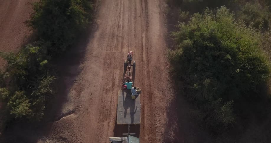 A tractor is pulling a trailer with people riding on it