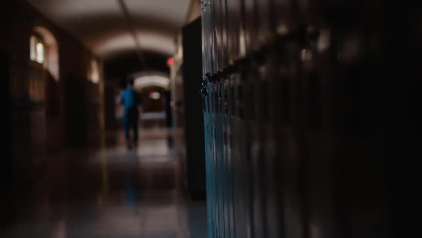 A man walks down a school hallway