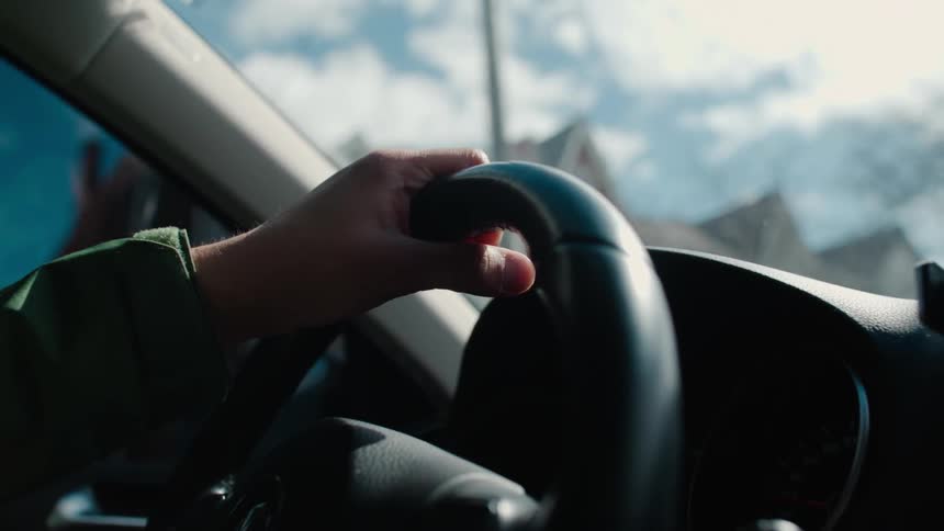 A person is driving their car past homes