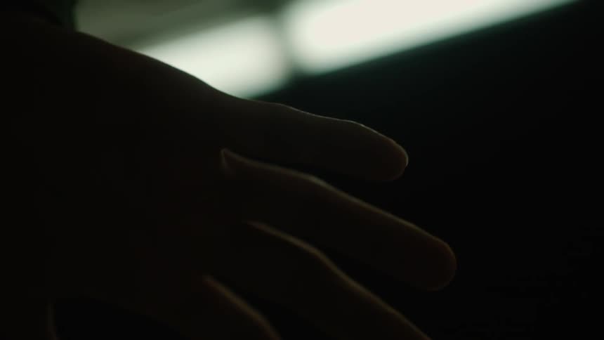 A person waves their hand in the dark