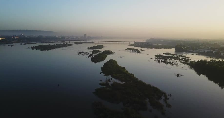 The sun sets over a bridge and body of water