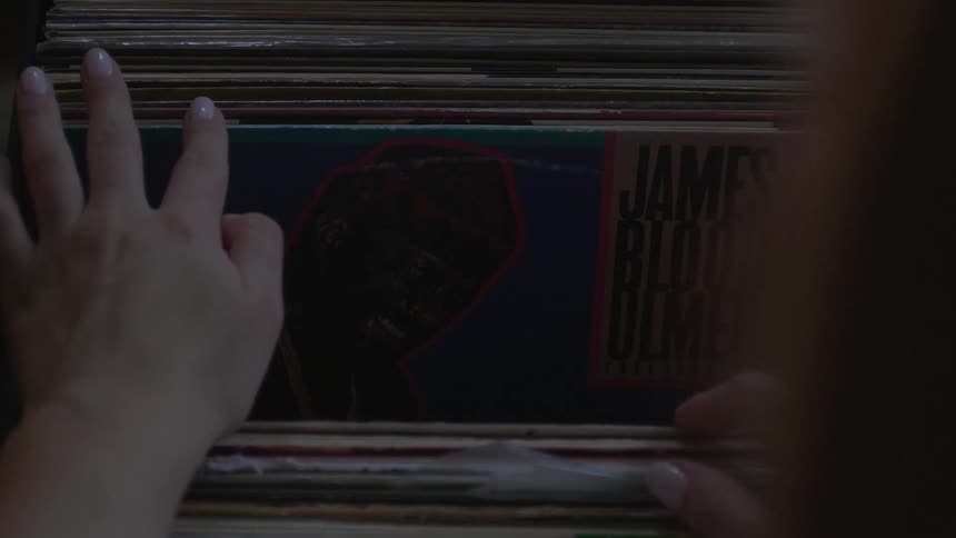 A woman looks through a stack of records