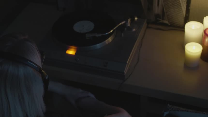 A woman listens to music using a record player