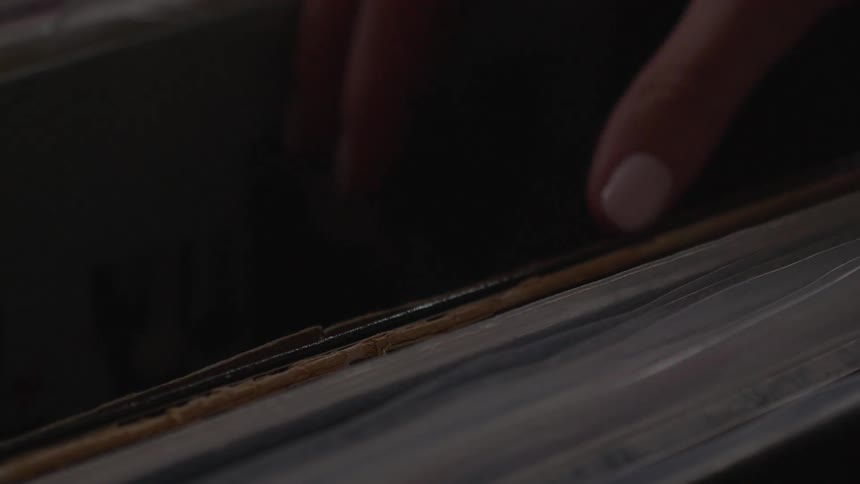 A woman looks through a box of records
