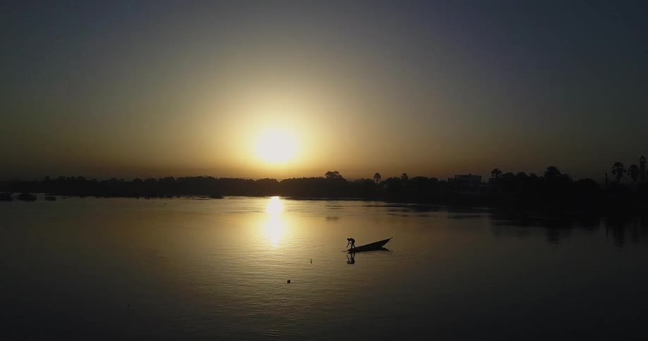Lone boat floats on the lake at sunset