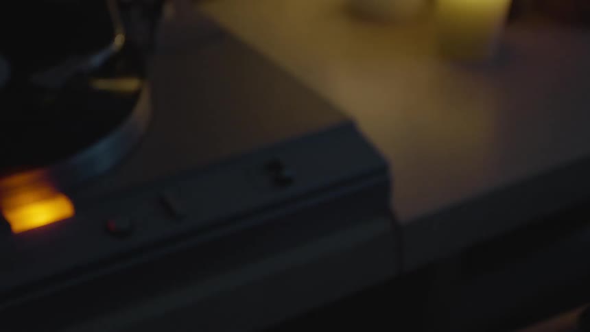 A woman sits next to a record player and sways her head