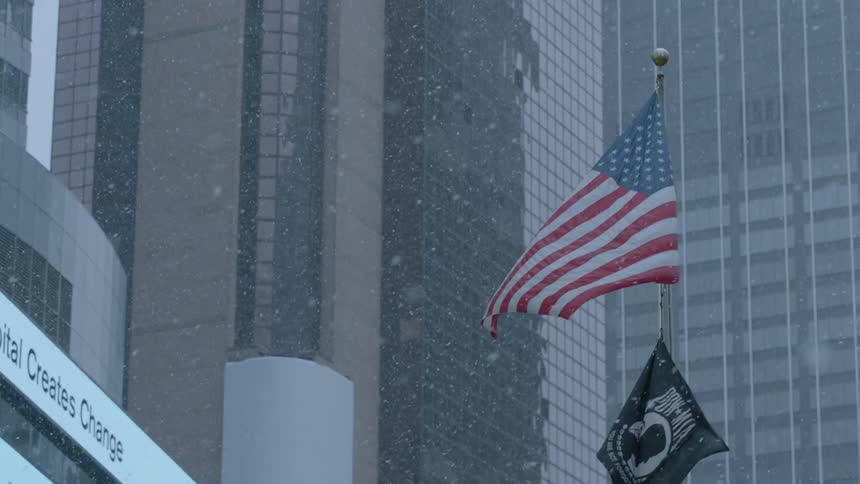 Flags flying on a city street on a snowy day