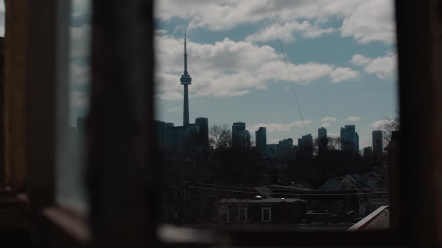 Outside the window a city of tall buildings are ahead