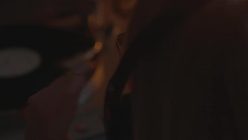 Person looks at a record player in dim light