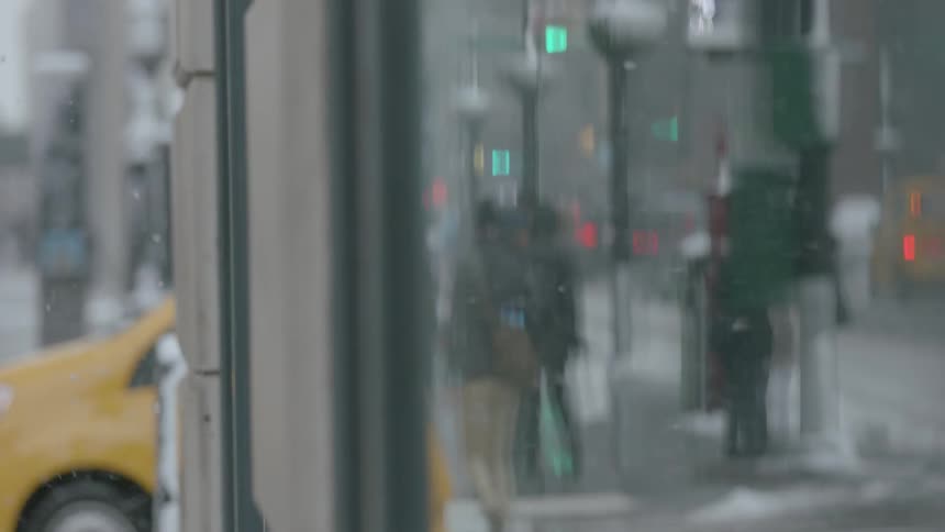 People walk in the snow past a building