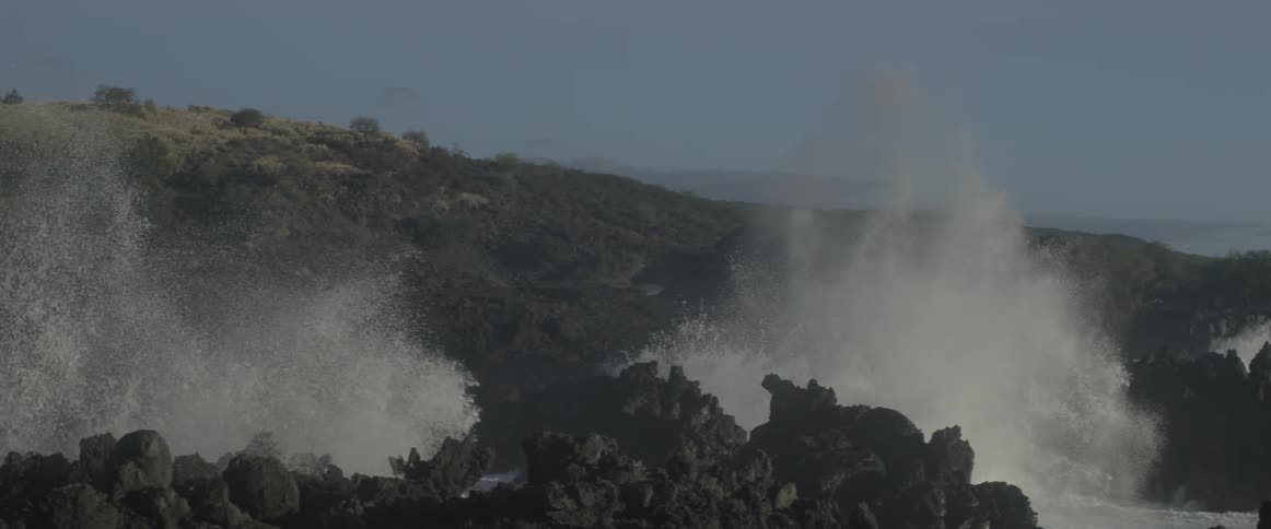 Ocean waves crash into a rocky shore