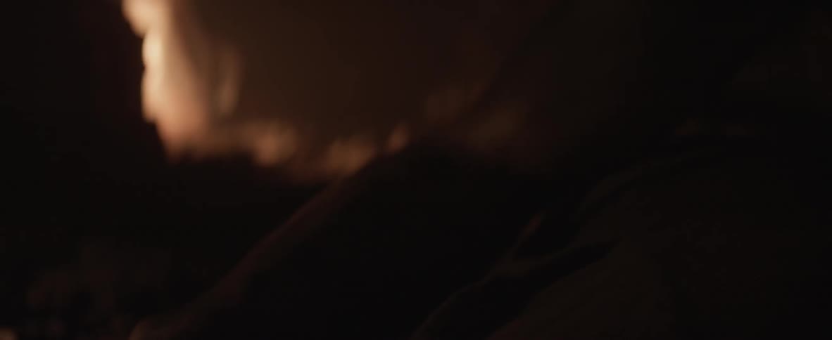 A man is in a dark cave chaining someone up