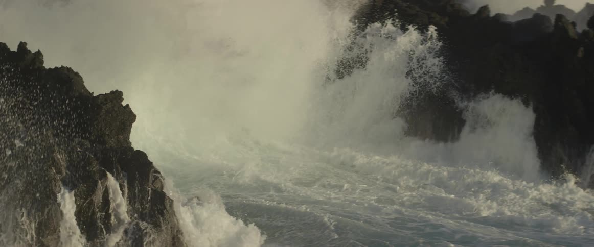 Ocean waves crash into a rocky shore