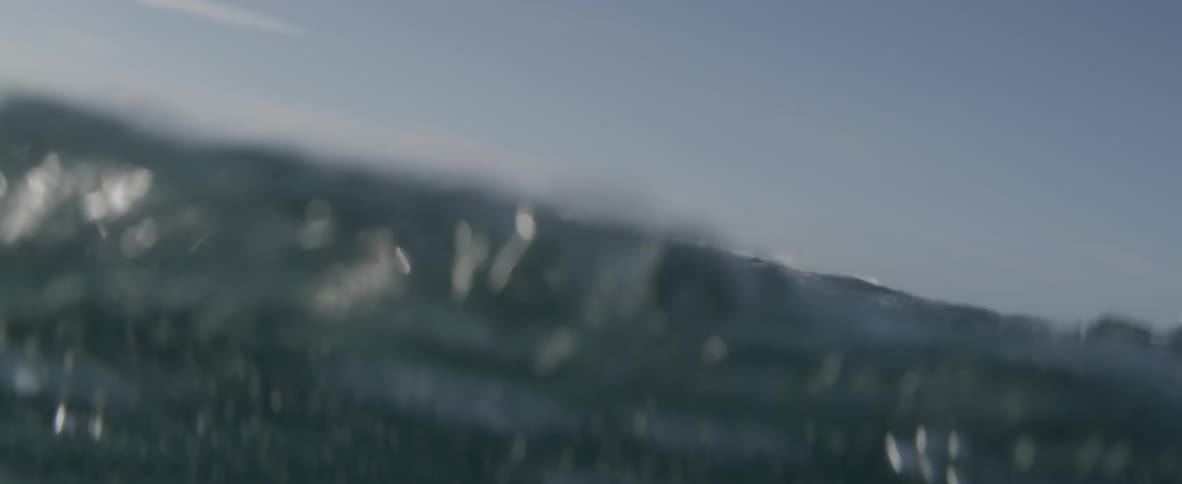 Man floating on raft in ocean waves on sunny day
