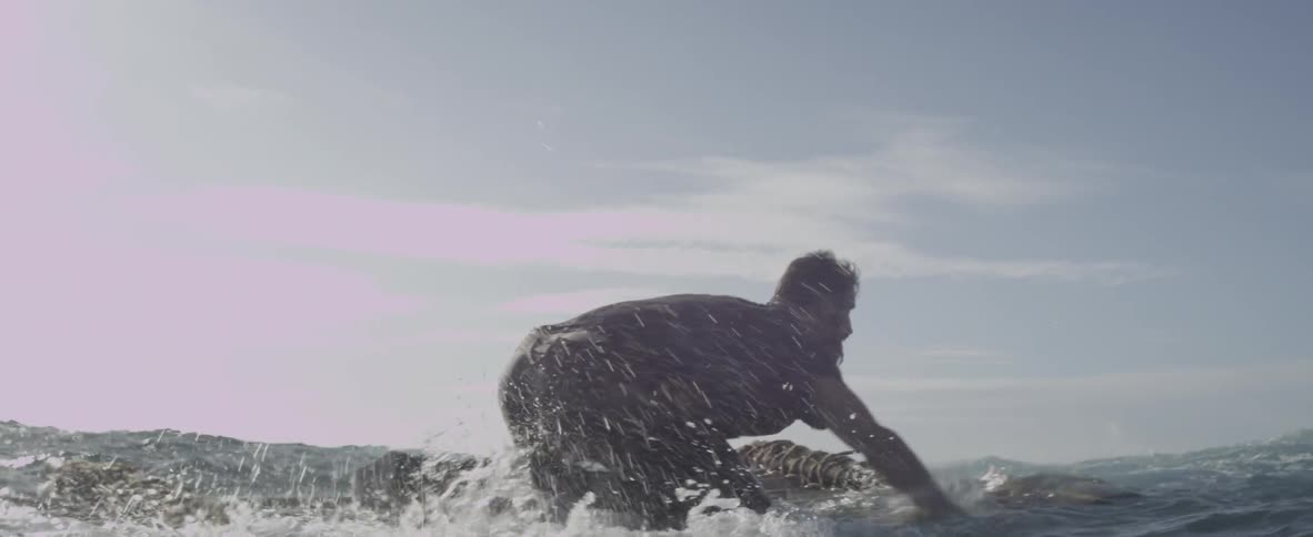 A man is paddling a makeshift raft on the ocean