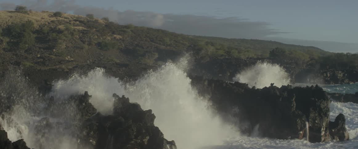 The shore is covered with jagged rocks and rough waves