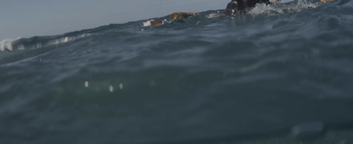 Person swim in the ocean and climbs onto a raft